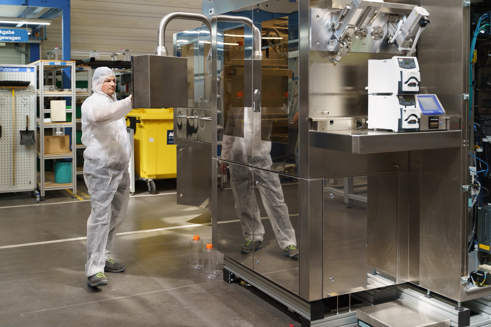 Employee in protective suit operating Labsun's automated cell culture production system